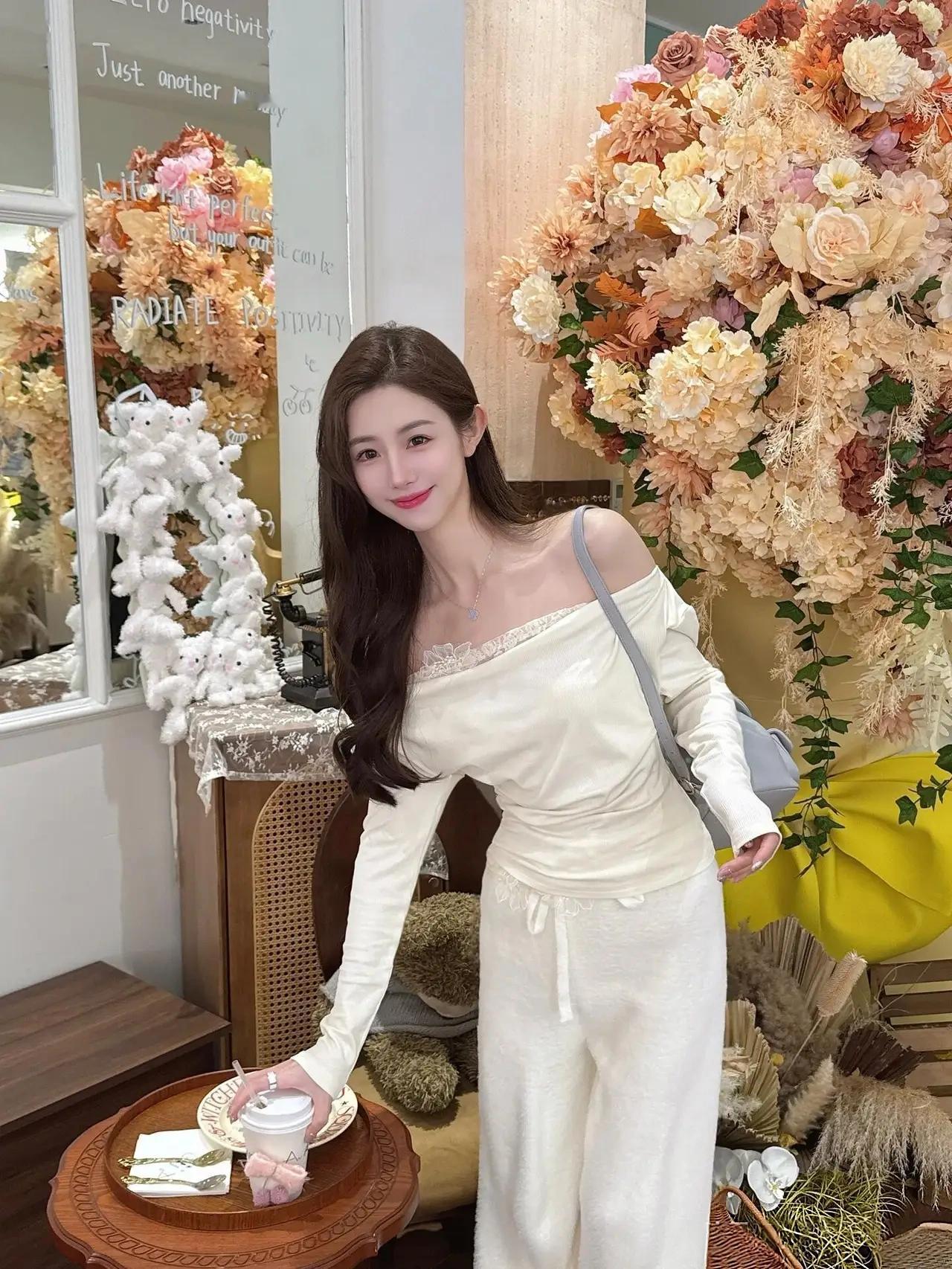 在这张精心装饰的环境中，一位女性正微笑着站在花墙前，仿佛置身于童话世界。她穿着一