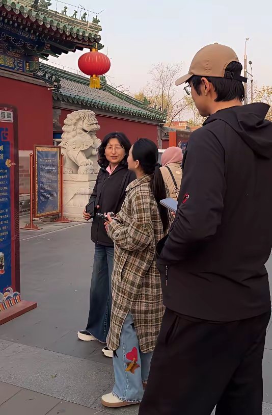 金莎和孙丞潇带着孙妈妈北京度假，穿着格纹长款大衣的金莎主动挽着婆婆手臂，笑容甜美