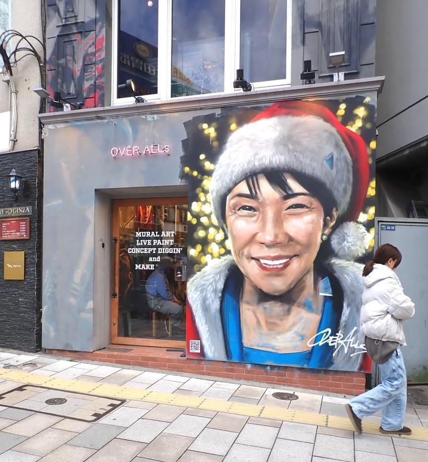 日本东京外园前站附近的 OVER ALLs 艺术画廊展示了一幅戴着圣诞老人帽的首