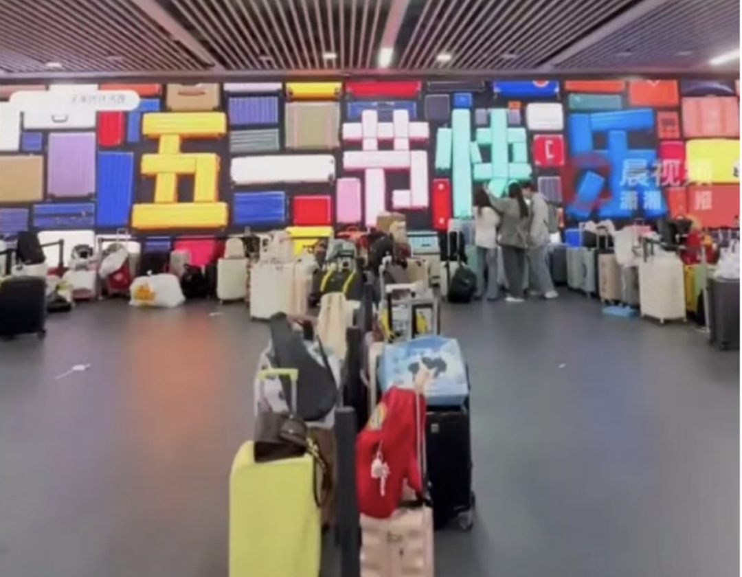 南京地铁出现行李墙 五一出行客流爆棚，南京地铁警务室门口，各式行李箱整齐排成长墙
