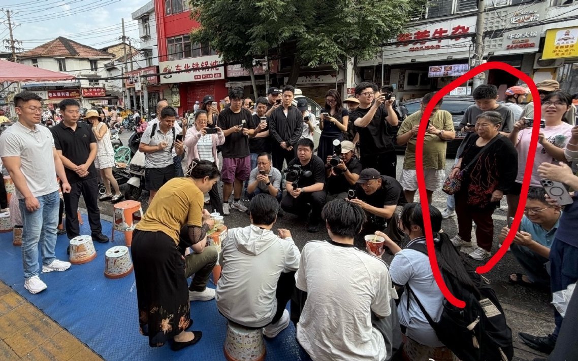 雷军武汉吃路边摊现场，很多人都在拍视频、拍照，可能只有这位大妈在全身心欣赏知名企