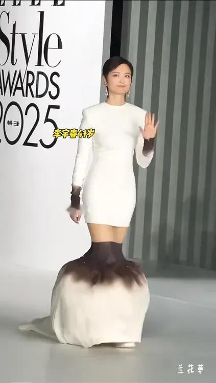 这是什么鬼设计？
41岁的李宇春穿着新设计的衣裙走秀台。看她走路时别别扭扭的，像