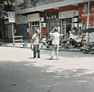 小伙子太明智了，始终两只手举过头顶，捂着头盔没还手，大爷抡圆了胳膊拿手里的包打小