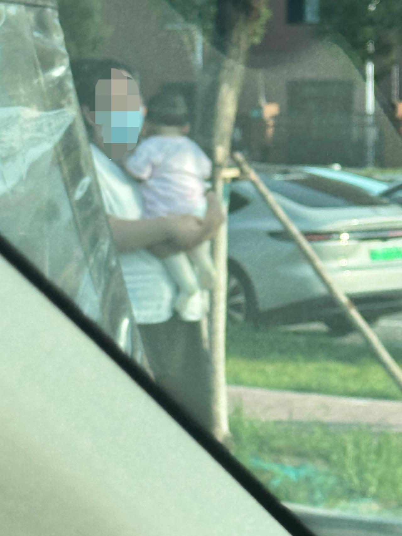 今天在学校门口停车场等着接孩子，我旁边停了一辆三轮车。一个30多岁的女人，从三轮