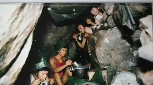上世纪80年代，老山前线，两名战士正在“猫耳朵洞”里吃饭，旁边放着一盒压缩干粮。