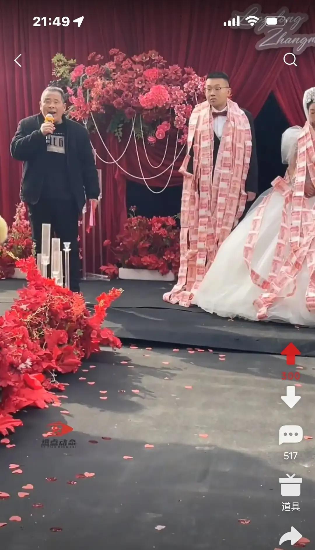 婚礼现场的视频一共不到1分钟，画面里灯光全是大红，台上只有两个人站在中间。
 