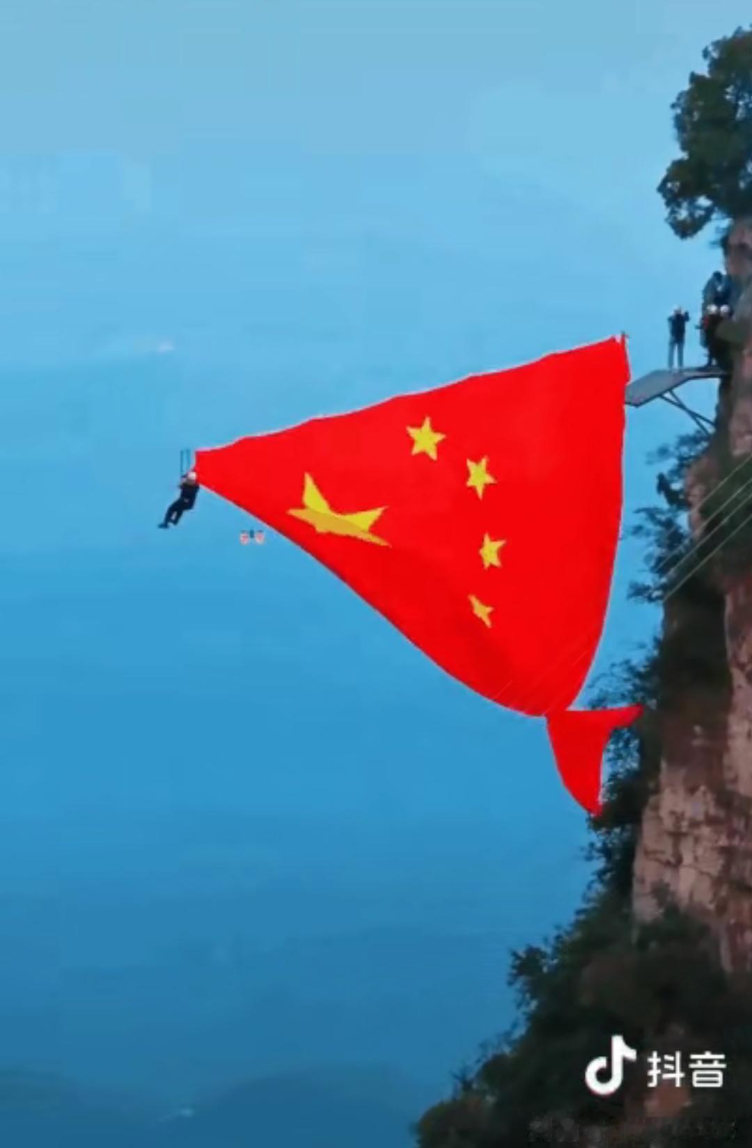 河南云台山，一网友去旅游刚爬到半山腰，看见有工作人员在挂巨幅五星红旗，原本累的不