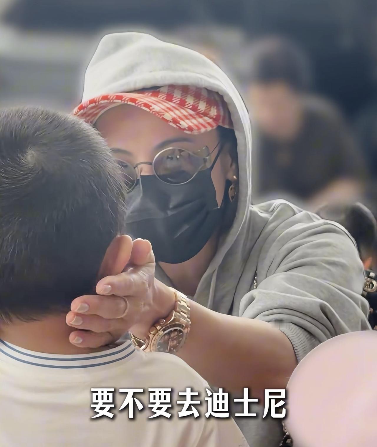 46岁张柏芝现身机场，和粉丝的孩子打招呼，亲切的抱着他捏脸逗孩子，是发自内心的喜