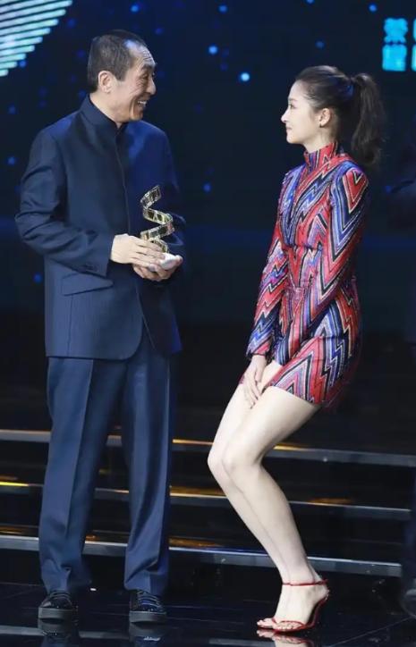 一次颁奖晚会上，张艺谋走向关晓彤时，只见她双腿紧闭，双手捂裙，双膝往下蹲。张艺谋