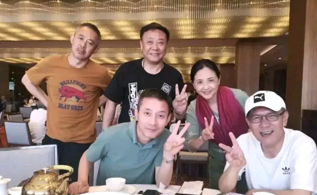 其他四位都做着同样的手势，唯独左边这位与众不同，他双手插腰，歪着脖子，很自信的样