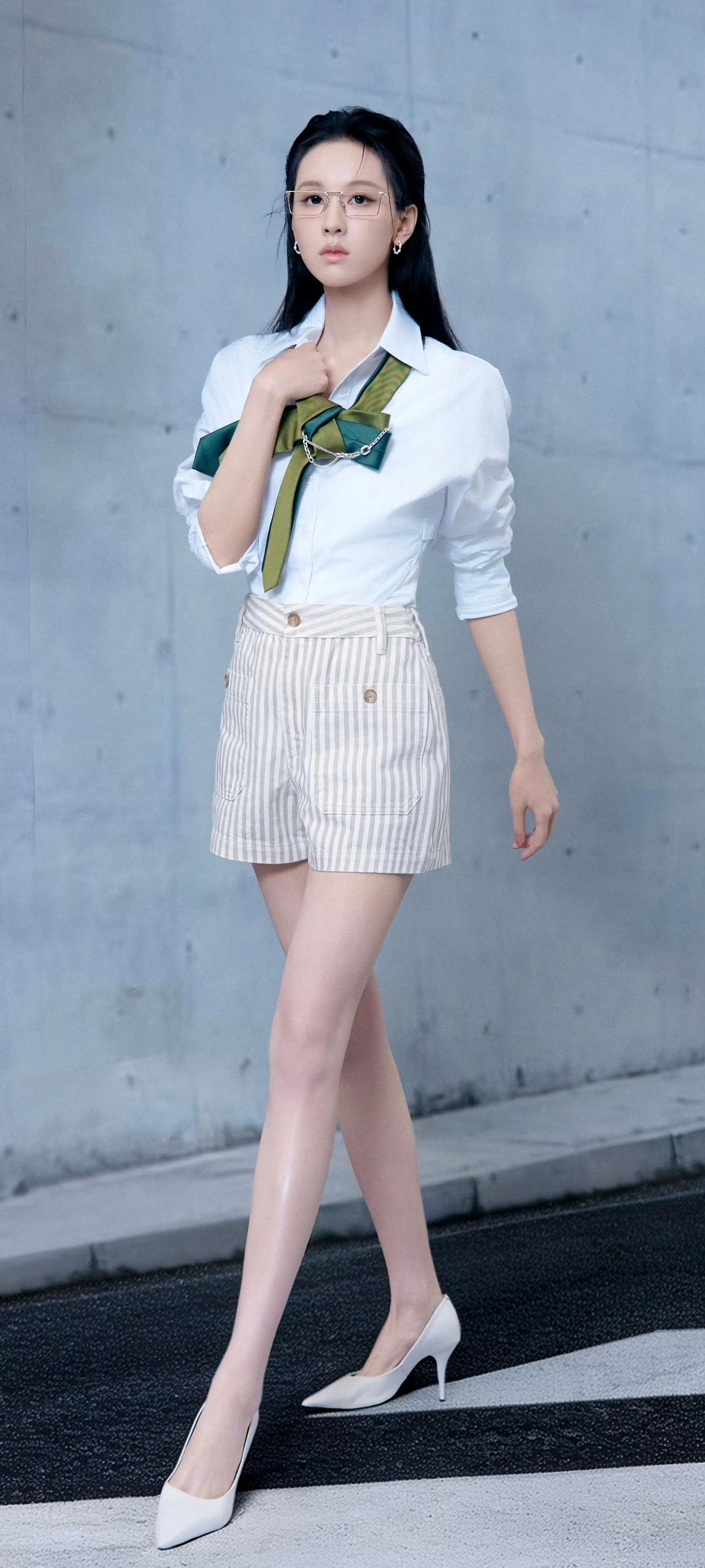 陈都灵的眼镜造型杀疯了！
金丝细框眼镜衬得眉眼清冷，白衬衫配撞色领结，条纹短裤勾