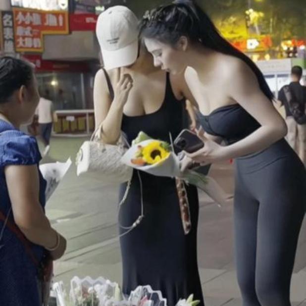 晚上逛街撞见暖心一幕，瞬间被打动！
 
夜市街边，两位打扮时髦的年轻姑娘，正低头