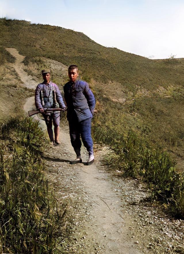 1942年，山路上走来一名八路军战士，他端着刺刀，押着一个男子往前走。仔细看，这