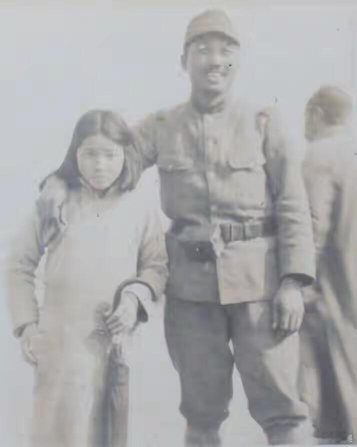 1938年的南京街头，一名日军士兵拦住过路的女孩，强行与她合影。鬼子肆无忌惮地将