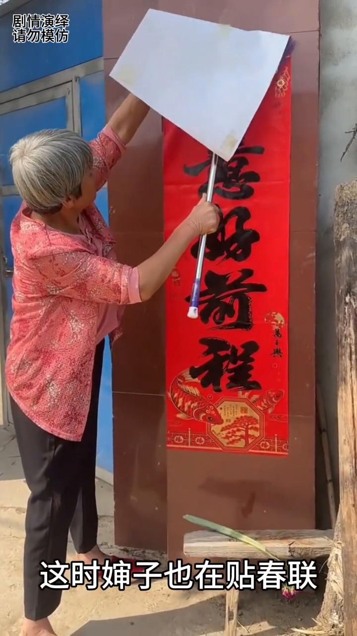 婶子巧妙一个人将春联贴上去，这一幕真的太有才了。
马上要过年了，只见家家户户都在