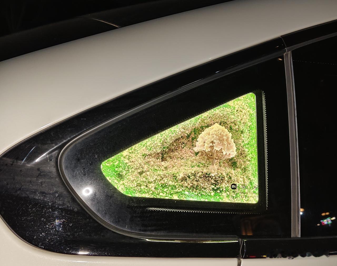 华灯初下的马路边，汽车后三角窗闪着绚丽的亮光，像嶙峋的山峦的缩写版。中间有气泡在