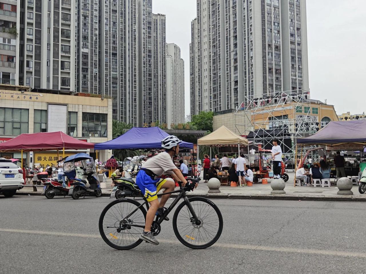 #记录夏日生活点滴# 清晨时分的城市街头，少年骑车经过，生命的活力和城市的喧嚣融