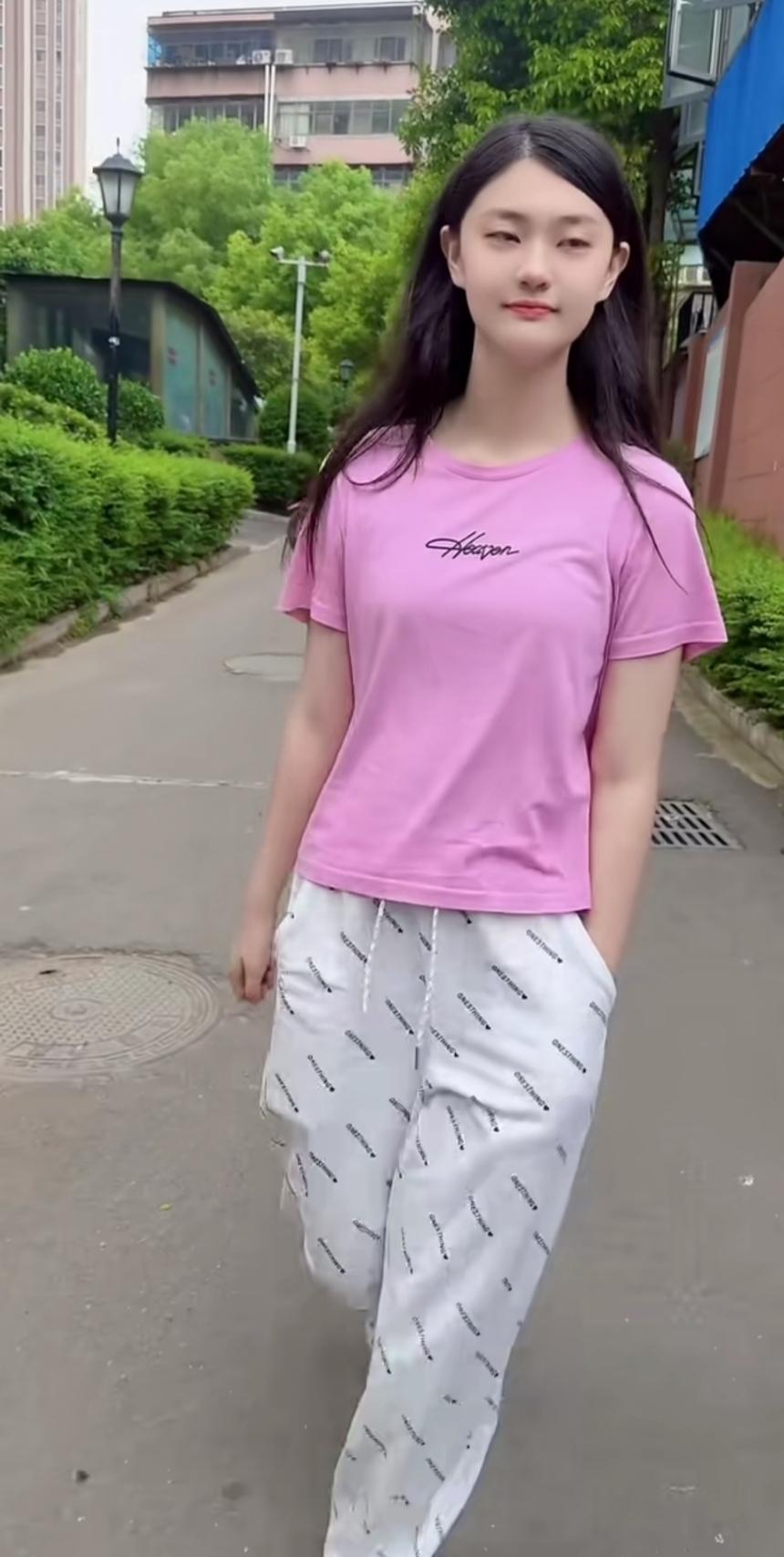 记录我的2026 穿粉色T恤和长裤在户外散步。阳光暖暖地洒在身上，每一步都踏在松