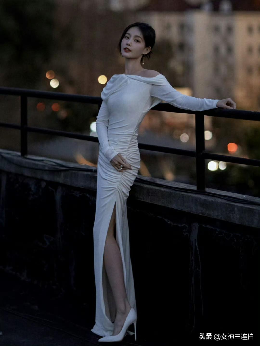 这姑娘穿着晚礼服站在栏杆旁，真优雅！