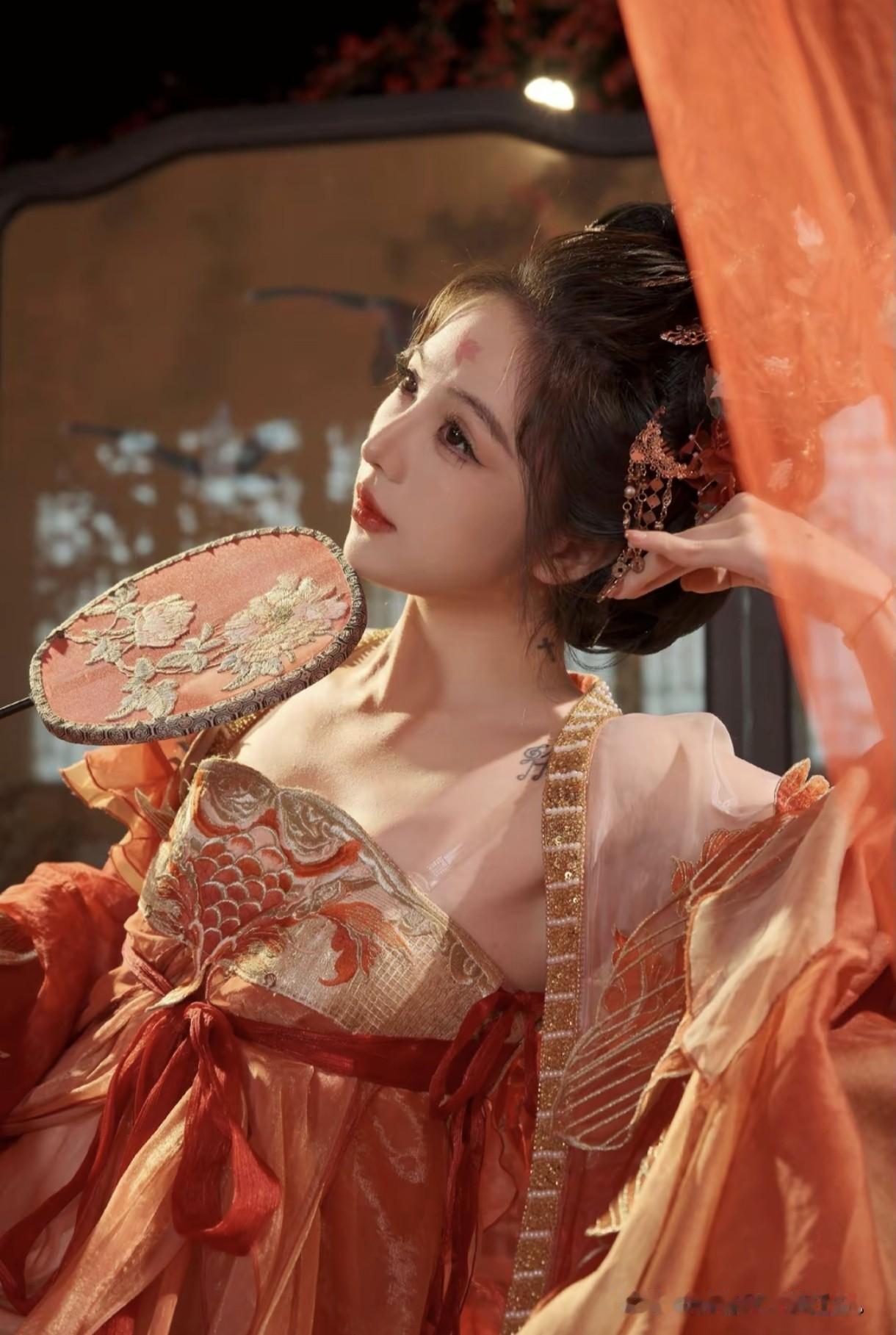 橘色纱衣随风舞，团扇半遮娇颜羞。这抹古风韵味太撩人，仿佛穿越千年遇见了梦中仙子！