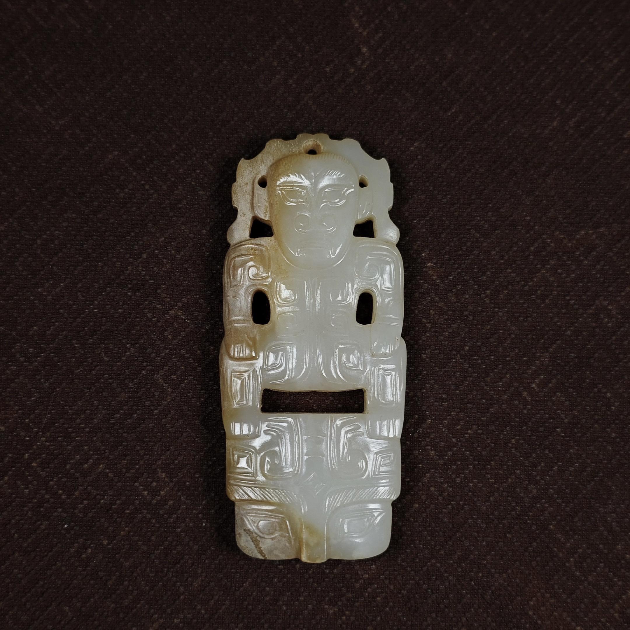 石家河文化玉神人兽面挂佩。神权象征：这类“神人兽面”佩饰是史前巫师通神...