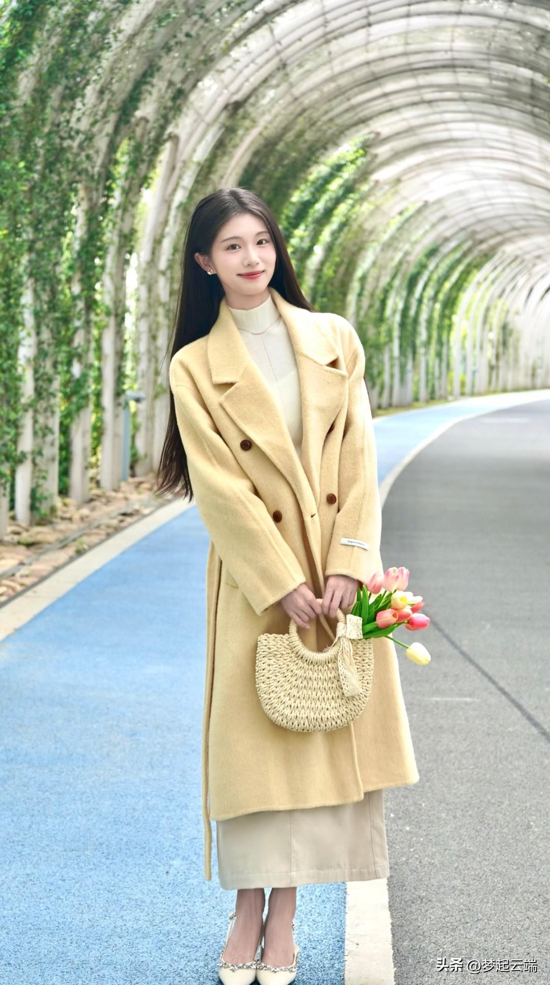 在绿意盎然的隧道里，她温柔地微笑，手捧一束花，散发着春天的气息。