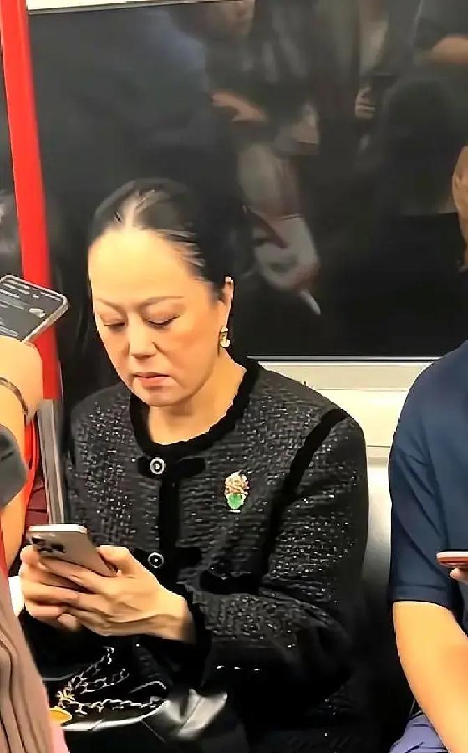 章小蕙坐地铁被偶遇，照片里她穿灰风衣靠门站着，头发被风吹得乱飞，眼袋法令纹全在，