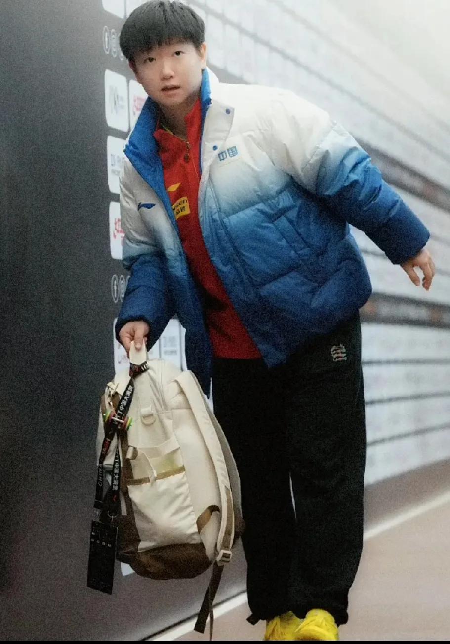 捕捉莎宝可爱瞬间。身穿国乒渐变队服，手提包包，小脑袋悄悄探出来，眼睛滴溜溜转，四