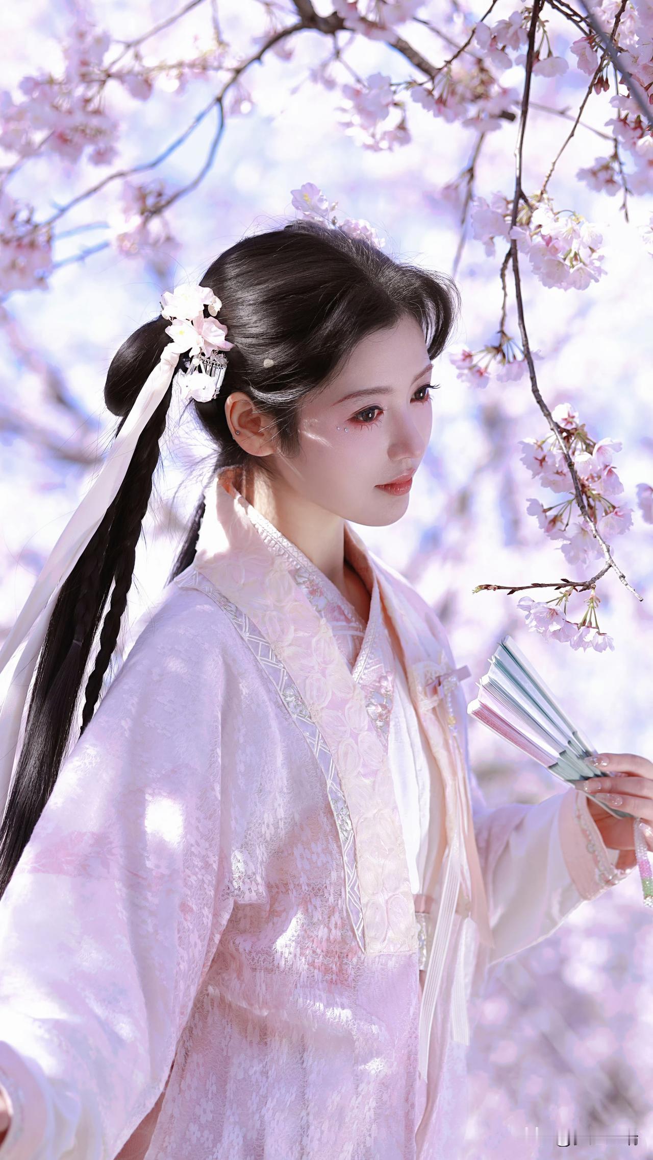 樱花树下，古装美人手持团扇，唯美如画。