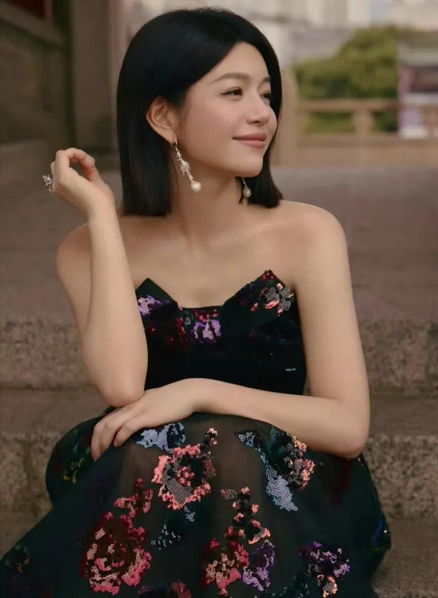 陈妍希似从水墨卷轴款款而来，黛色抹胸礼服与红墙相映成画。单侧垂落的丝绸结带如泼墨