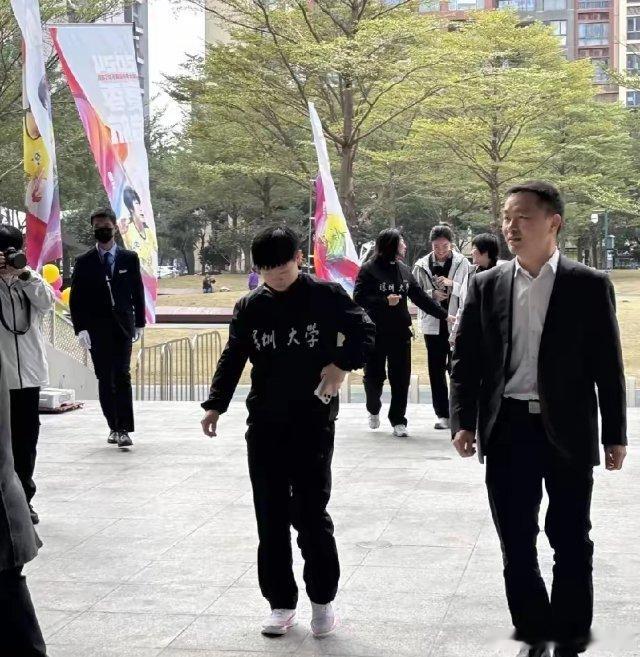 莎莎现身深圳大学参加活动，一身黑色队服又酷又飒。看到莎莎啦，人群中小小的一只，但