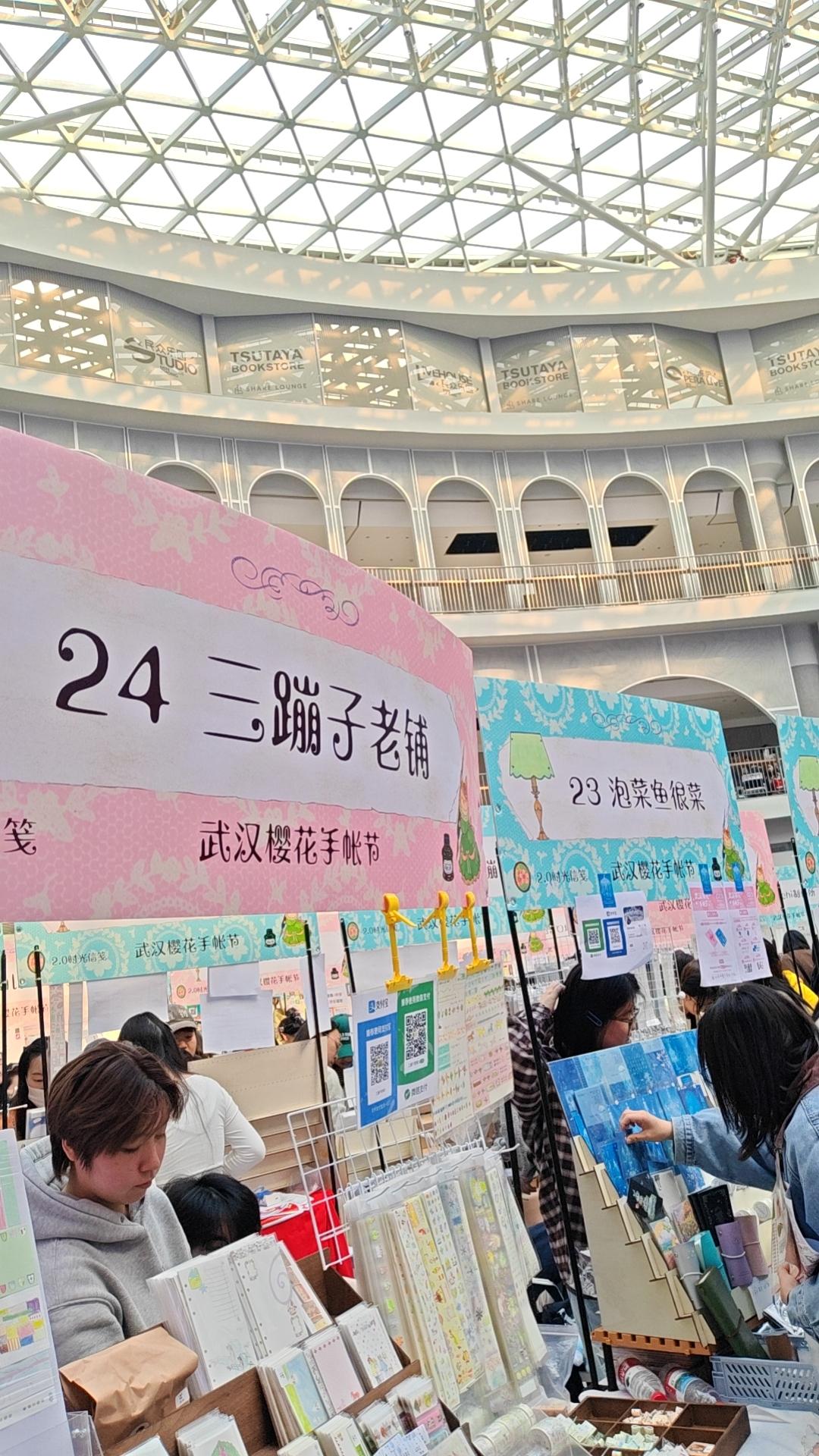 手帐集市在一楼大厅，整体以“樱花”为设计主题，粉色弥漫。摊位上的商品丰富多样，有