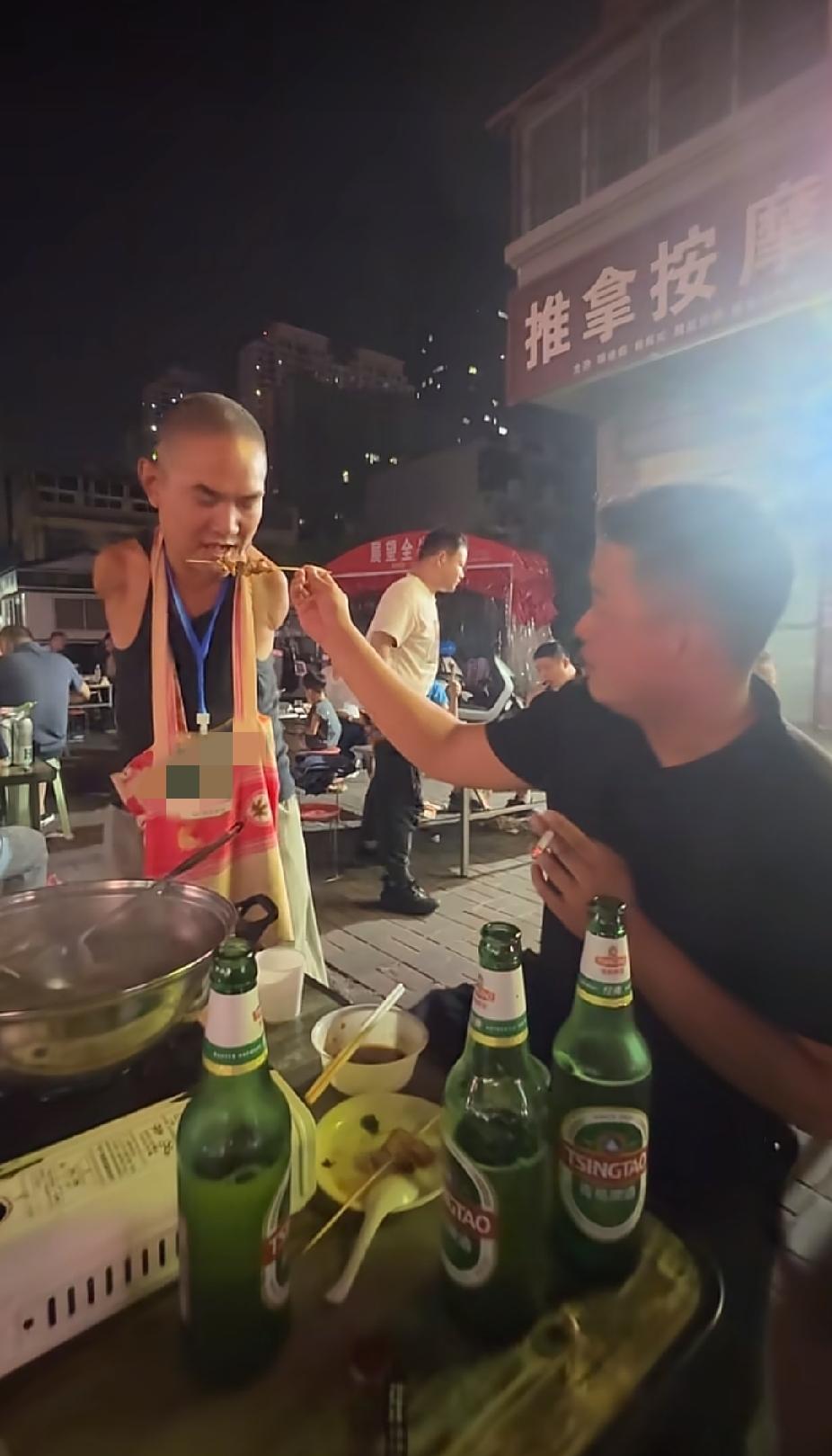 路边夜宵摊前，一名男子和朋友正在吃夜宵，男子突然做出的一个举动，让人直呼感动了。