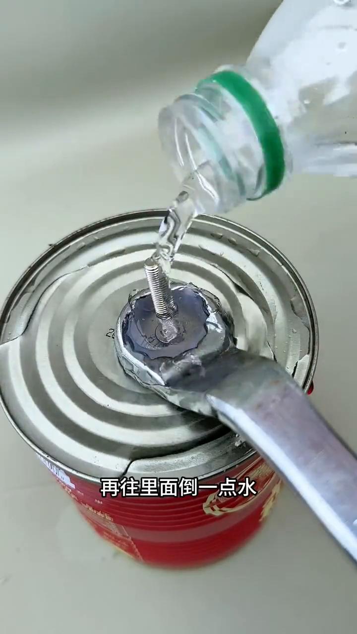 制作手动加大螺丝方法。
注意看，把扳手放在铁板上，再倒一点水，然后往里面打满热熔