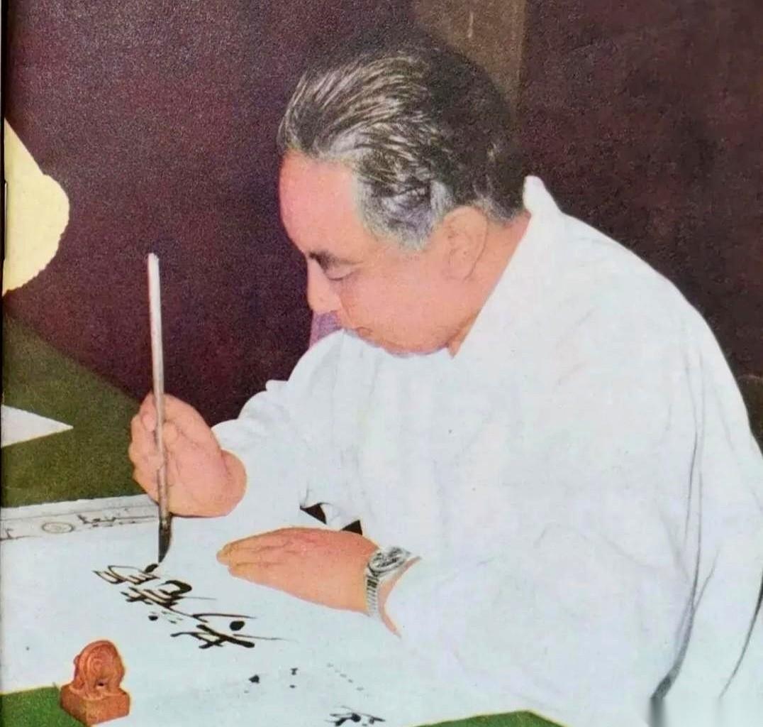 刷到一张老照片，一下子就被定住了。
1980年。一个穿白衬衫的男人，在写字。
就