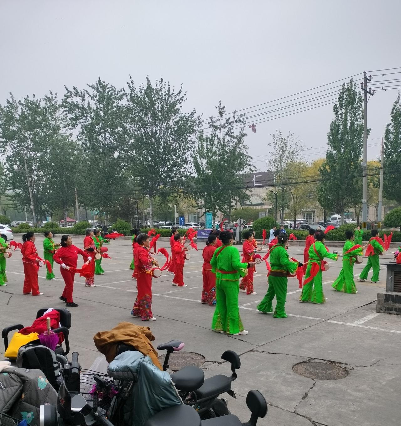 那日驻足尚街广场，眼前的画面格外戳心！
左边锣鼓喧天，大爷大妈们身着彩衣，敲着腰