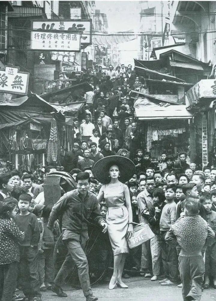 1962年，香港街头的外国模特，营造出一种时尚与传统的反差感。
现在的香港街头貌