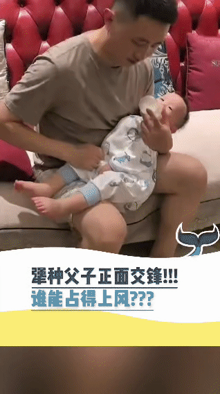 被这对父子给逗乐啦！奶爸坐在沙发上， 专心致志地给宝宝喂奶。小家伙倒好，喝着喝着
