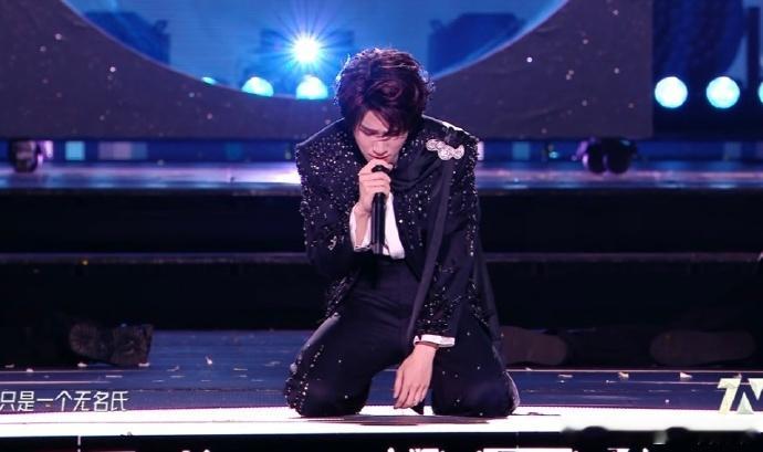 张真源跪下张真源下跪像求婚场面暖调柔光铺满演出舞台，张真源单膝跪地静静垂眸看向灯
