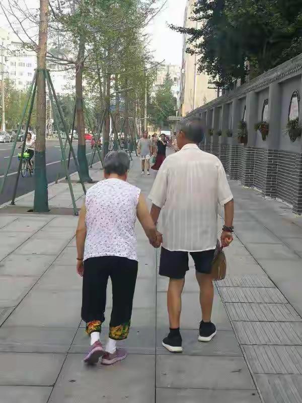 《小时候她牵我，长大后我牵她》

天气渐黑，小区广场人也多了，前面两个人牵手而行