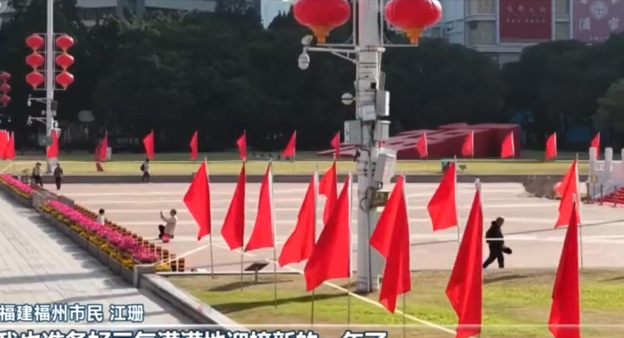 新年将至，福州的城市街头与花市一同被年味包裹。广场上，鲜红的旗帜整齐排列，红灯笼