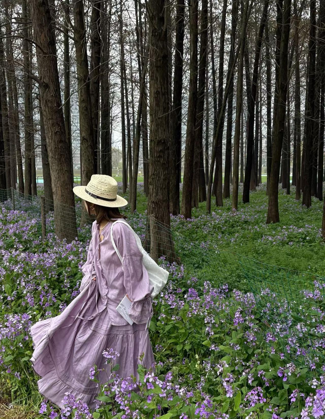 林间漫遇一片紫色花海，
一身温柔浅紫长裙，一顶草帽，
踩着春风，携书本与闲情，