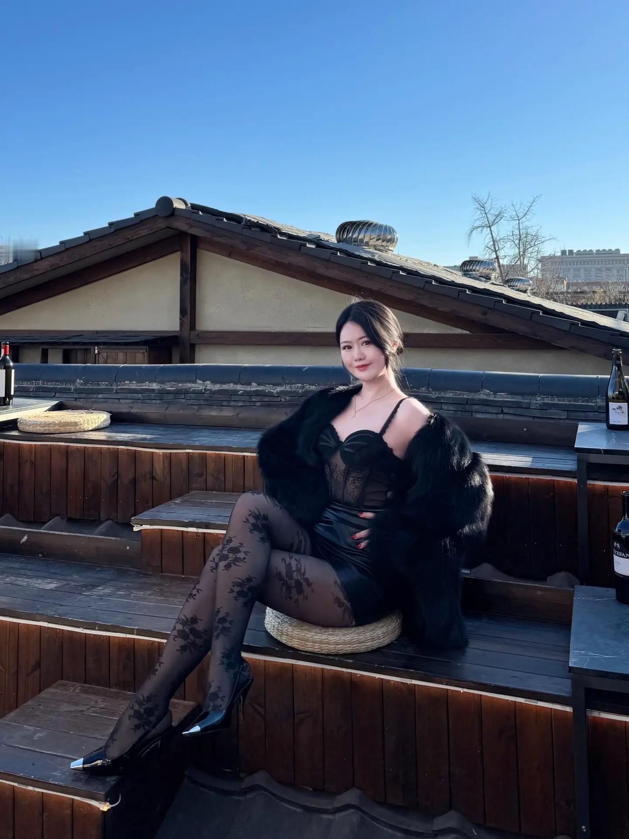 冬日暖阳下的咖啡馆，优雅黑衣女子与美酒相伴。