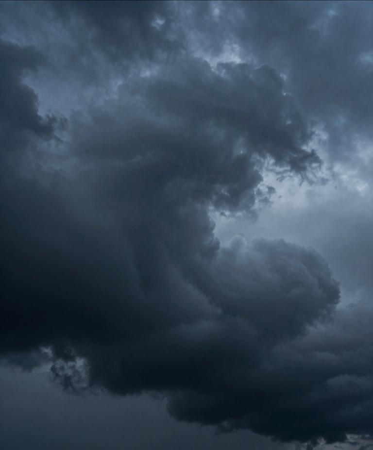 云团层层叠叠，底部呈现出深邃的炭灰色，仿佛吸走了世间所有的光线。而在云层的缝隙间