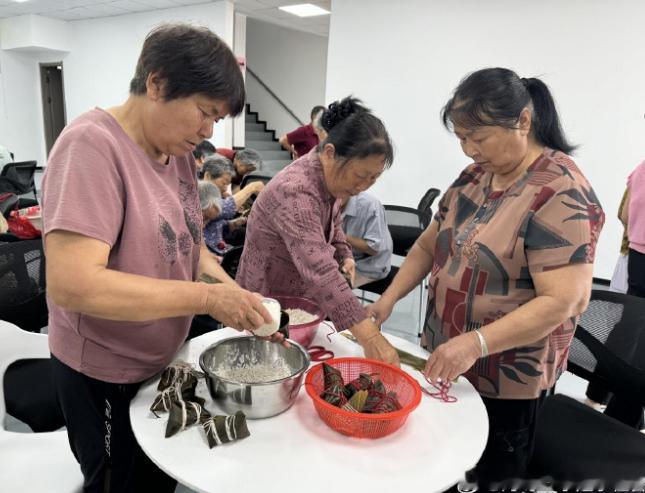 粽香飘满台州邻里围坐包出幸福味 活动现场布置妥当，长桌之上粽叶、糯米、蜜枣、棉线