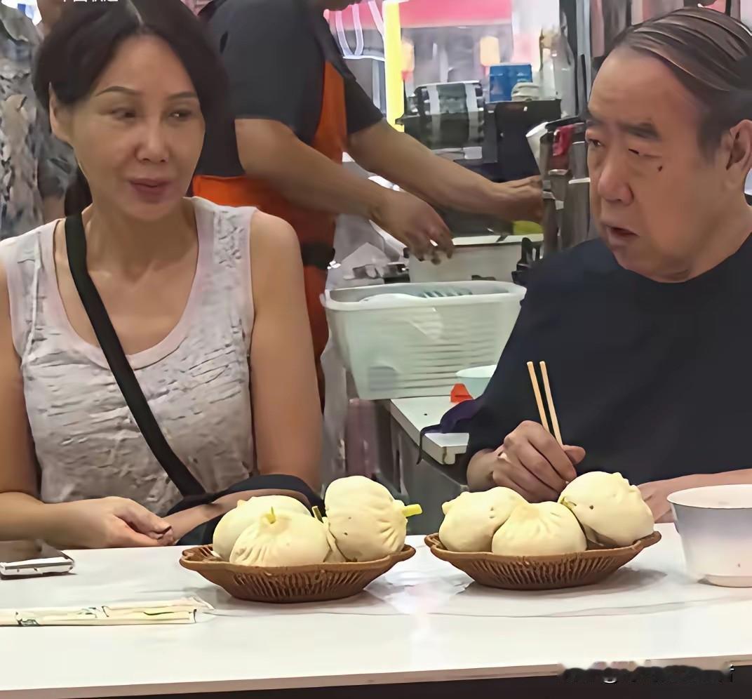 贾平凹和小他17岁的妻子罕见一起外出吃包子，
郭梅是他第二任妻子，八十年代改革之