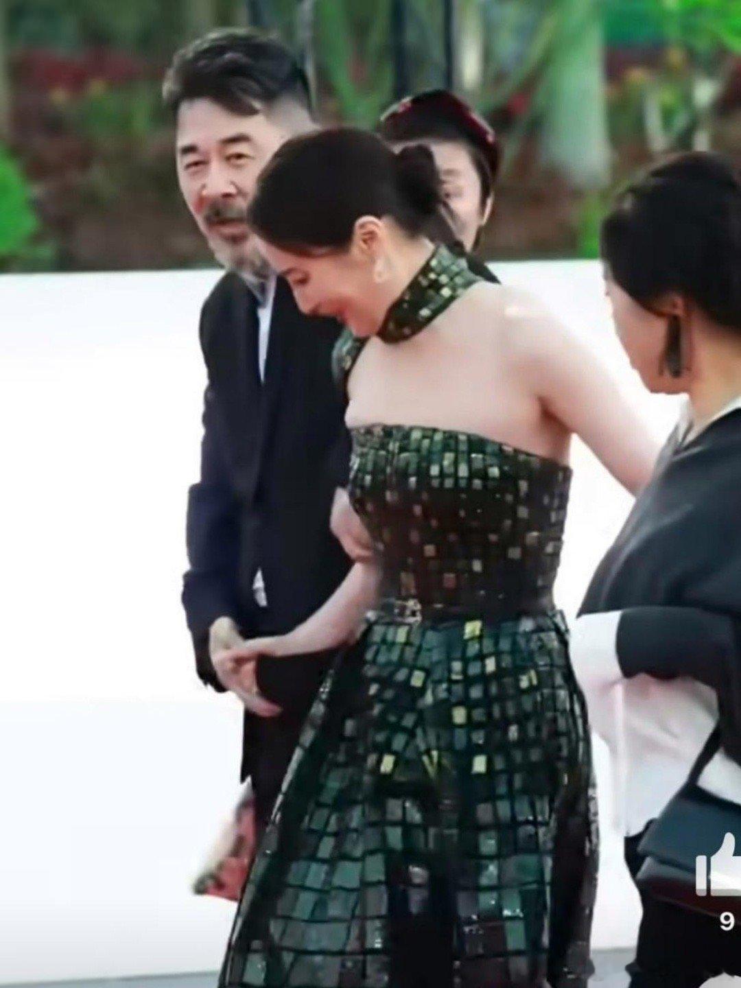 金鸡红毯上，蒋勤勤身着"麻将裙"的礼服走红毯时，因裙摆过长意外绊倒。一旁老公陈建