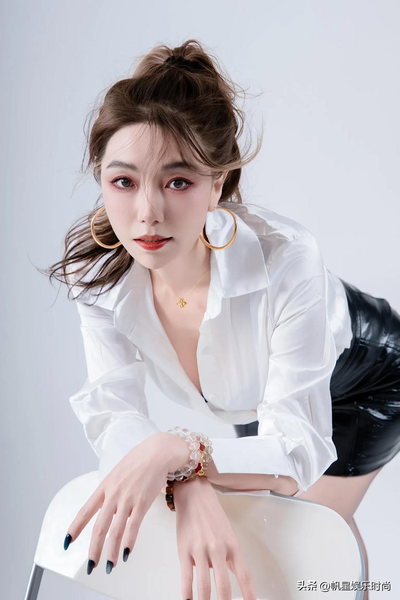 这件宽松的白衬衫微微敞开，消减了正式感，增添了随性韵味。黑色皮质短裙收紧身形，尽