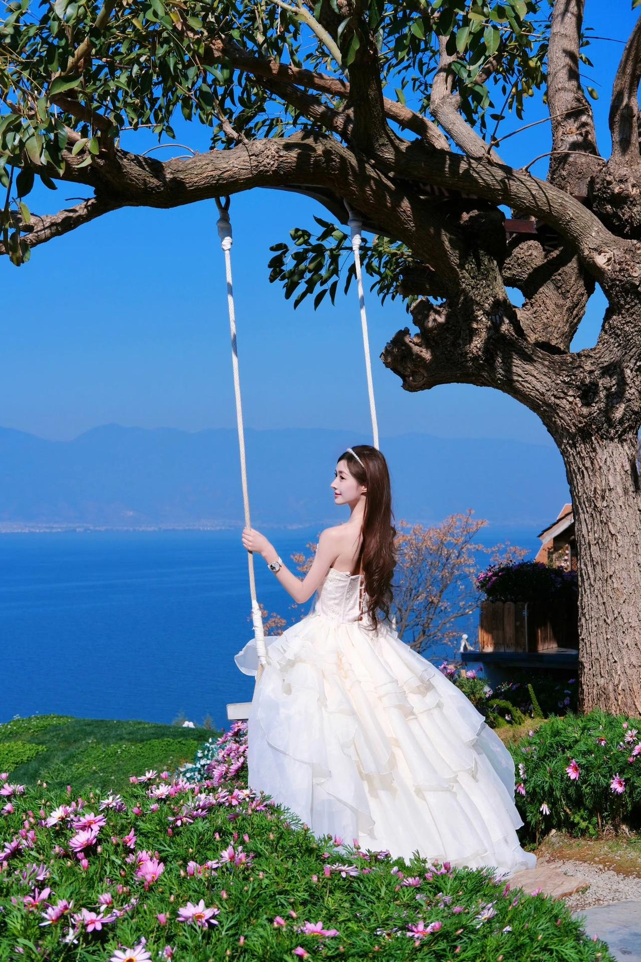 蓝天为幕，碧海为台，繁花簇拥着一袭白裙。

裙摆随风扬起，在山海与花境之间，闯入