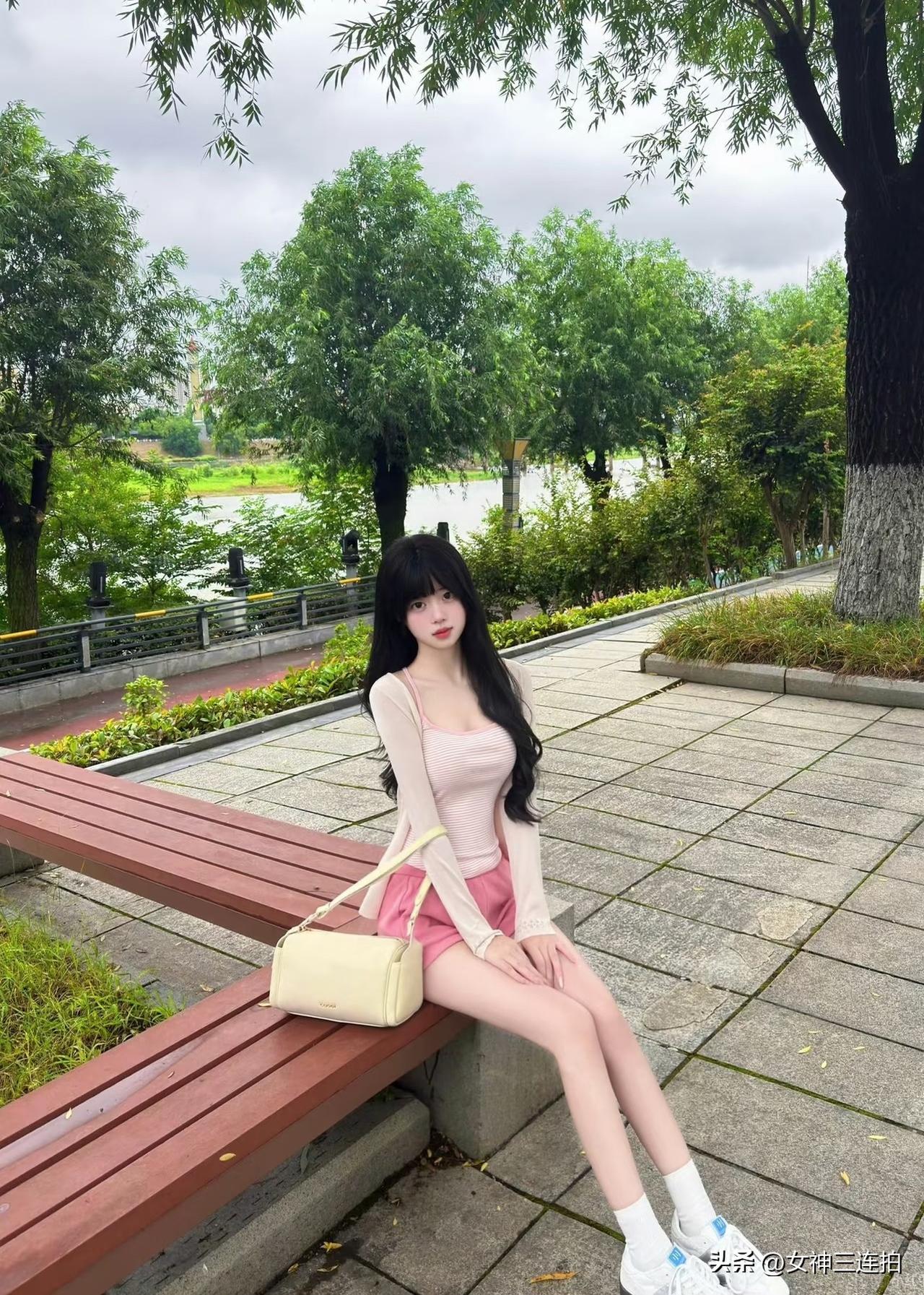 公园长椅上的清新少女，粉色裙摆与自然绿意相映成趣。